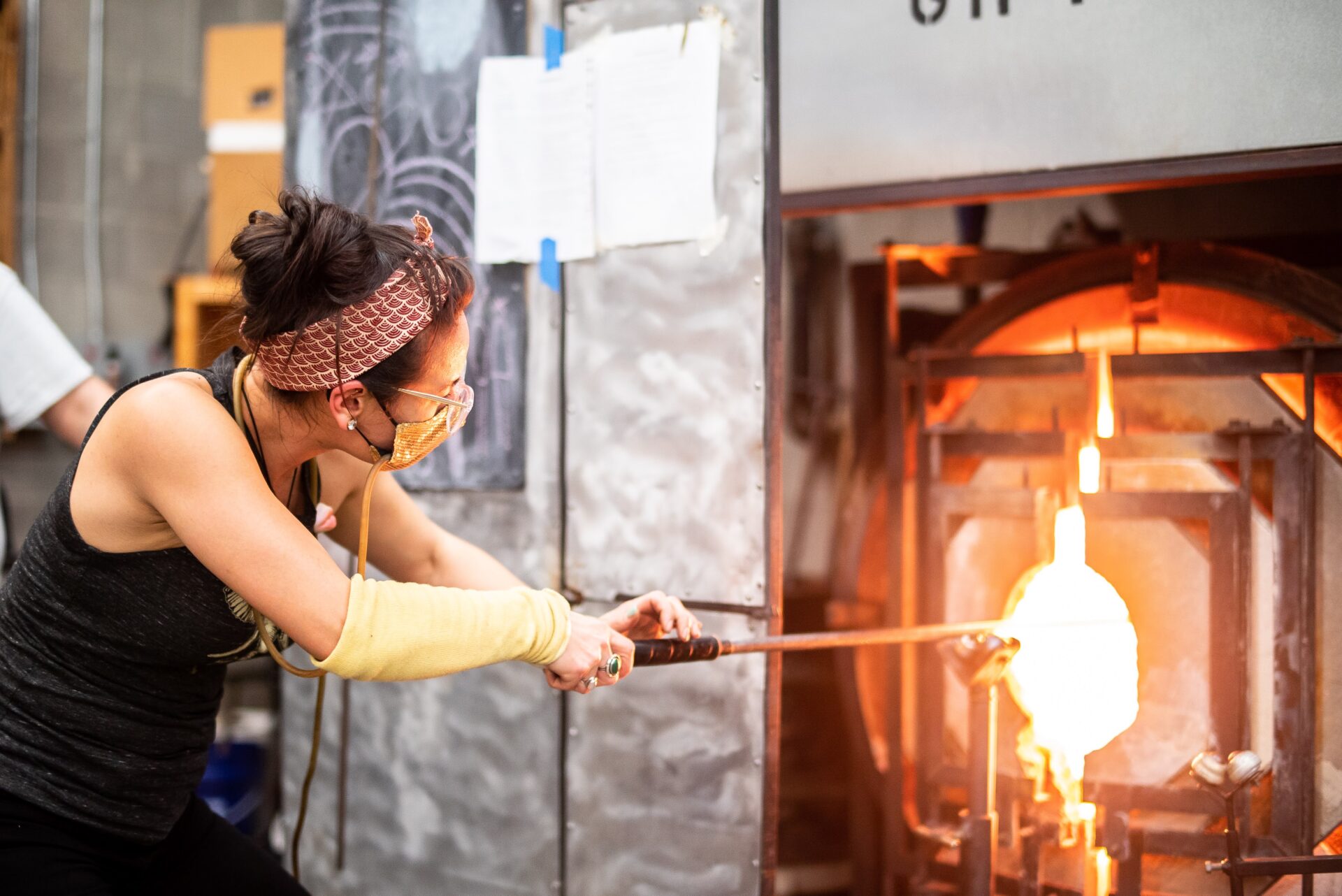 Minhi heating the glass in a reheating chamber called a "glory hole"